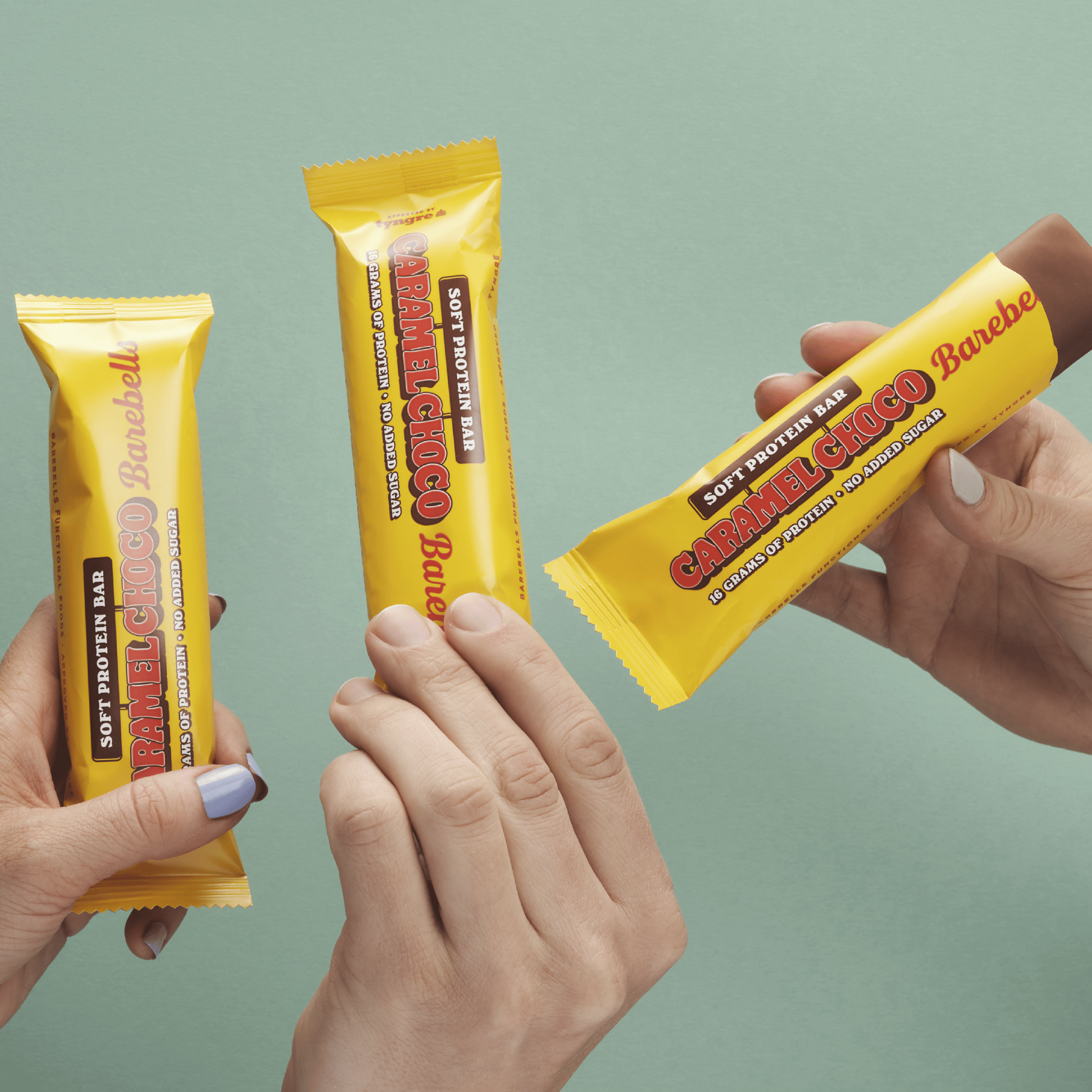 Barebells Soft Protein Bar Caramel Choco - drie eiwitrepen in handen - sfeerfoto